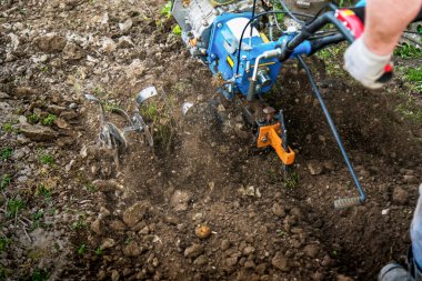 Bahçedeki toprağı motorlu ekiciyle sürüyorum.