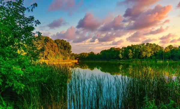 Picturesque evening nature landscape by the lake with dramatic sky. Forest Lake. Park with a lake.