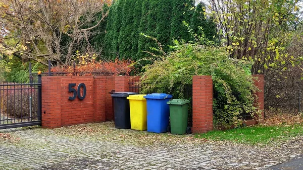 Plastic colorful trash cans containers fog garbage sorting waste. Recycle trash bins outdoor view. Containers for collecting garbage near the yard on the street.