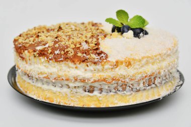 Hindistan cevizli lezzetli ev yapımı kek, sütlü çikolata ve yaban mersini ve nane yapraklarıyla süslenmiş fındık..