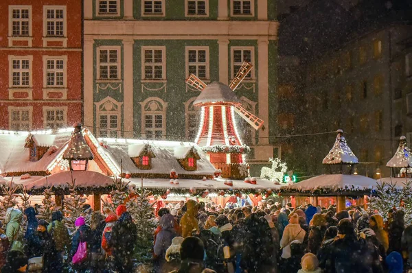 Wroclaw, Polonya, Noel pazarı, Avrupa 'da Noel' de popüler bir turizm merkezi. Akşamları eski şehir merkezinde, kar yağışı. Birçok insan akşamları Noel pazarında gezinir..
