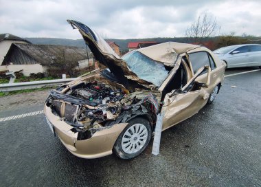 Islak yolda ağır bir trafik kazası. Hayati tehlikesi var. Otomobil ön tarafta hasar gördü. 