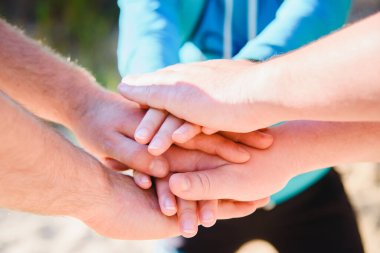 İnsanlar ve arkadaşlar arasındaki ilişki kavramı. Erkekler ve kadınlar ellerini birleştirdiler..