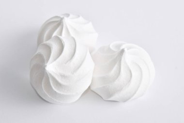 Beyaz arka planda üç beyaz pofuduk pasta, manzarayı kapat