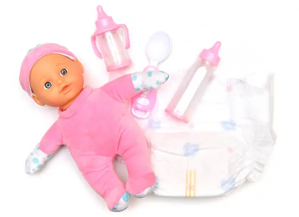 stock image Baby doll, diapers, pacifier and bottles for feeding a baby on a white background. Taking care of the child.