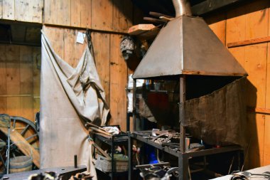 Blacksmith's shop inside, workbench and tools in an old-fashioned workshop factory room clipart