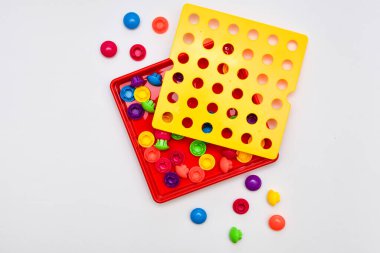 Beyaz arkaplana saçılmış plastik askılarla renkli çocukların tahta oyunu. Eğitici oyuncak, iyi motor beceriler, yaratıcılık ve el-göz koordinasyonuna yardımcı olur..