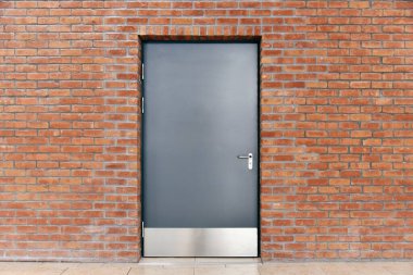 Modern metal giriş kapısı tuğla duvarda 