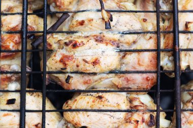 Izgaradaki ızgarada kızarmış tavuk kanatları.