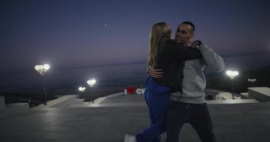 Mutlu çift deniz kenarındaki akşam şehrinde eğleniyor.