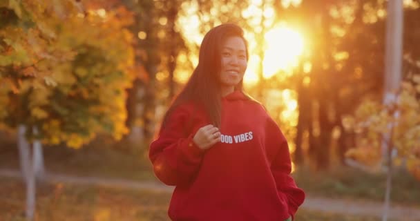 秋天阳光明媚的公园里 一个亚洲微笑的女人画像 动作缓慢 — 图库视频影像