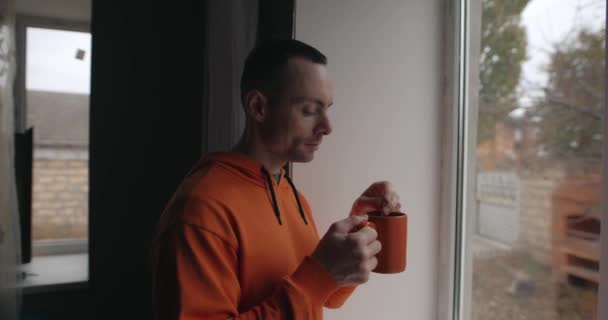 Mężczyzna Pije Herbatę Stojąc Domu Pobliżu Okna Oryginalne Audio Cenie — Wideo stockowe