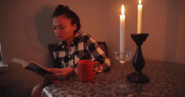 Wanita Membaca Buku Dalam Cahaya Lilin Rumah — Stok Video