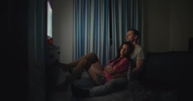 TV izleyen çift akşamları birbirlerine sarılıyorlar.