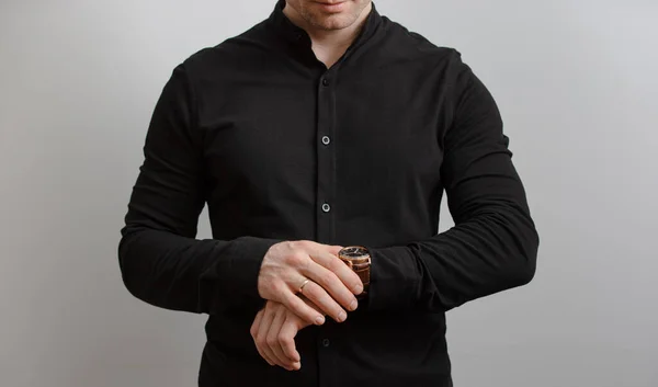 Неузнаваемый Мужчина Черной Рубашке Проверяет Время Наручных Часах Сером Фоне — стоковое фото