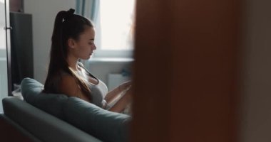 Young woman knitting plaid at home