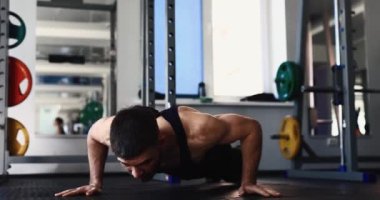 Spor salonunda alkış plyometrik şınav çeken adam.