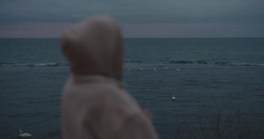 Akşamları deniz manzarasına bakan ve hayal kuran bir kadın.