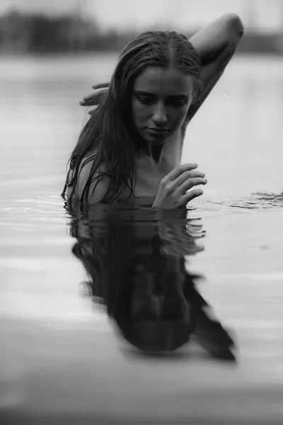 在湖中游泳的裸体妇女的黑白画像 — 图库照片