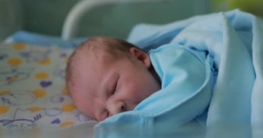 Yeni doğmuş bir bebek bebek beşikte yatar ve doğum hastanesinde uyur.