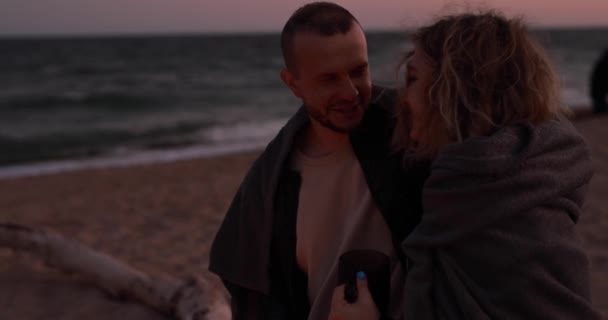 Homem Envolve Sua Namorada Cobertor Enquanto Senta Perto Mar Fogo — Vídeo de Stock