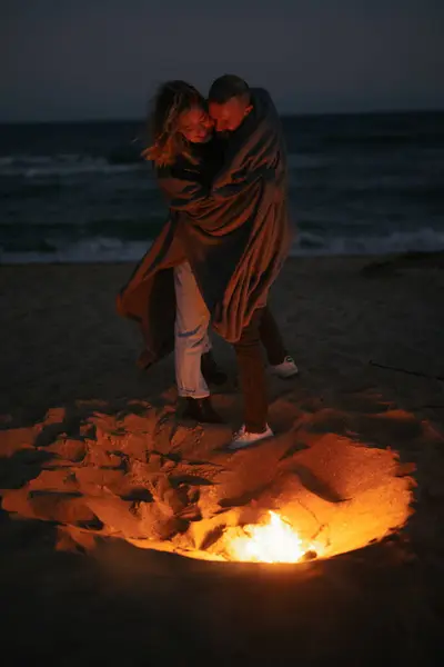 Pár Zamilovaný Objímání Při Stání Ohně Mořském Pobřeží Večer — Stock fotografie