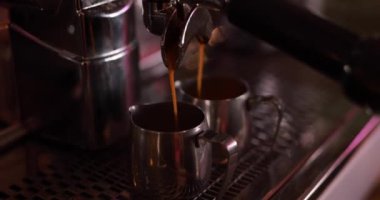 Kahve makinesi espresso yapıyor, kahve fincanlara dökülüyor.