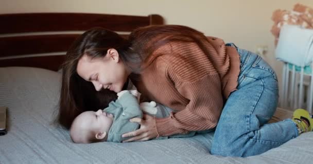 Заботливой Молодой Маме Нравится Играть Маленьким Мальчиком Лежащим Спине — стоковое видео