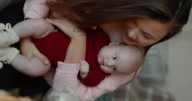 Küçük çocuk annesinin saçını çekiyor, dikey video.