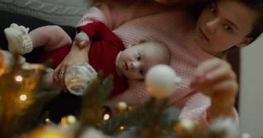 Noel ağacını Noel 'den önce tutan ve süsleyen kadın dikey video.