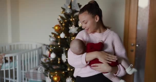 여자는 크리스마스 방에서 그녀의 아기를 Lulls — 비디오