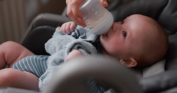 Малыш Пьет Молоко Бутылки Лежащей Стуле — стоковое видео