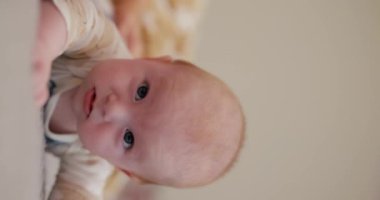 Güzel küçük çocuk yatağında yüzüstü yatıyor, dikey video.