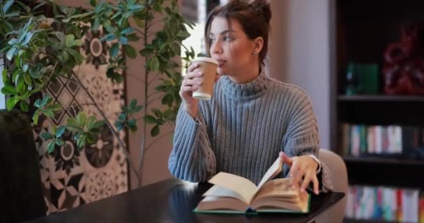Młoda Kobieta Czyta Książki Pije Kawę Siedząc Kawiarni Przy Stole — Wideo stockowe