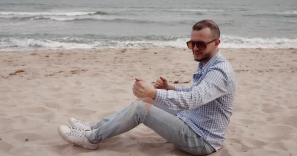 Een Man Strooit Zand Uit Zijn Hand Het Strand — Stockvideo