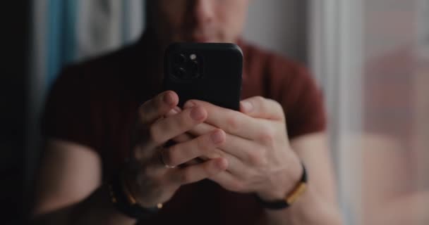 ブレスレットに男性の手を閉じる 携帯電話を使っている男 男はスマートフォンにメッセージを書く — ストック動画