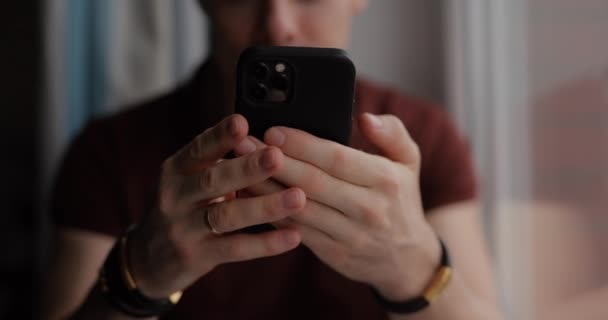 ブレスレットに男性の手を閉じる 携帯電話を使っている男 男はスマートフォンにメッセージを書く — ストック動画