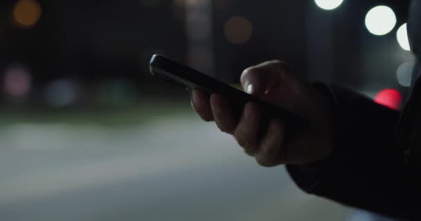 Mano Masculina Usando Smartphone Ciudad Nocturna Cerca Carretera — Vídeos de Stock