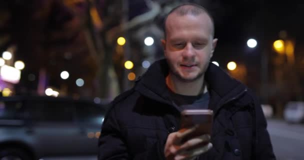 Hombre Usando Teléfono Inteligente Caminando Por Calle Ciudad Nocturna — Vídeos de Stock