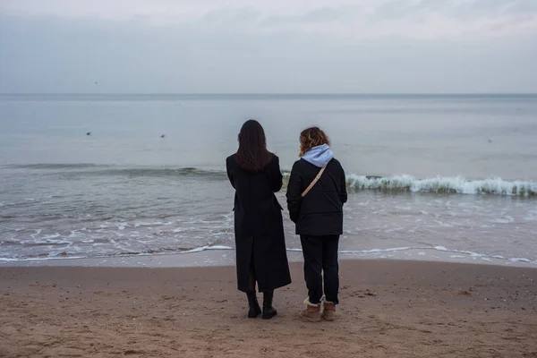 สาวสองคนมองไปท ทะเลฤด หนาว มมองด านหล — ภาพถ่ายสต็อก