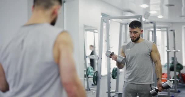 Hombre Entrenando Bíceps Con Pesas Pie Cerca Del Espejo Gimnasio — Vídeo de stock
