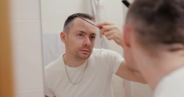 Bir Adam Aynaya Bakarken Saçını Tarıyor Kendinden Emin Gülümsüyor — Stok video