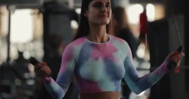 Genç seksi kadın spor salonunda ip atlama egzersizi yapıyor.