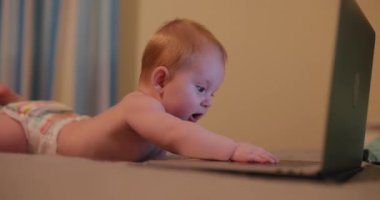 Küçük bir çocuk evde bilgisayar korsanı gibi bilgisayarla oynuyor.