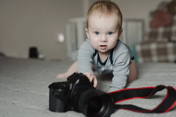 自宅でカメラで横たわっている小さな少年写真家 ストック写真