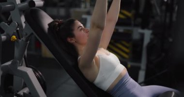 Spor salonunda göğüs egzersizi yapan bir kadın.