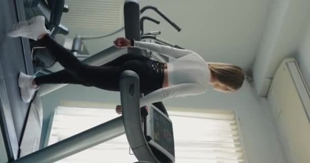 バックビュー 垂直ビデオでトレッドミルで運動する女性 — ストック動画