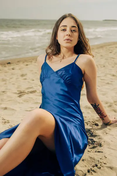 Όμορφη Γυναίκα Μπλε Φόρεμα Κάθεται Στην Παραλία Της Θάλασσας Εικόνα Αρχείου