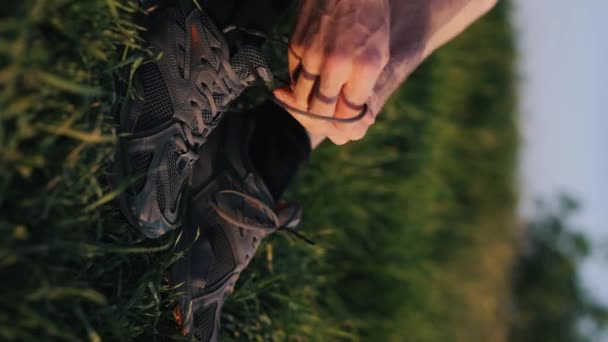 Male Hands Tie Shoelaces Sportive Sneakers Nature Vertical Video — стоковое видео