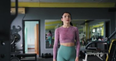 Spor salonunda kulaklık takan kadın, ağır çekimde.